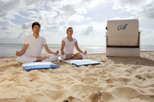 Paar meditiert am Strand (c) Cliff Hotel